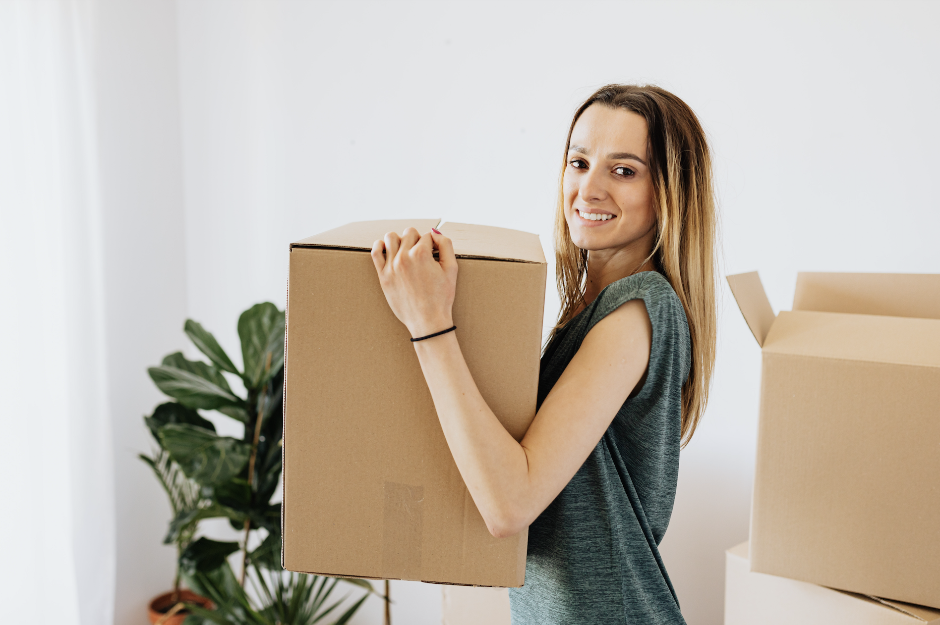 Günstig umziehen_lachende Frau beim Kisten Packen