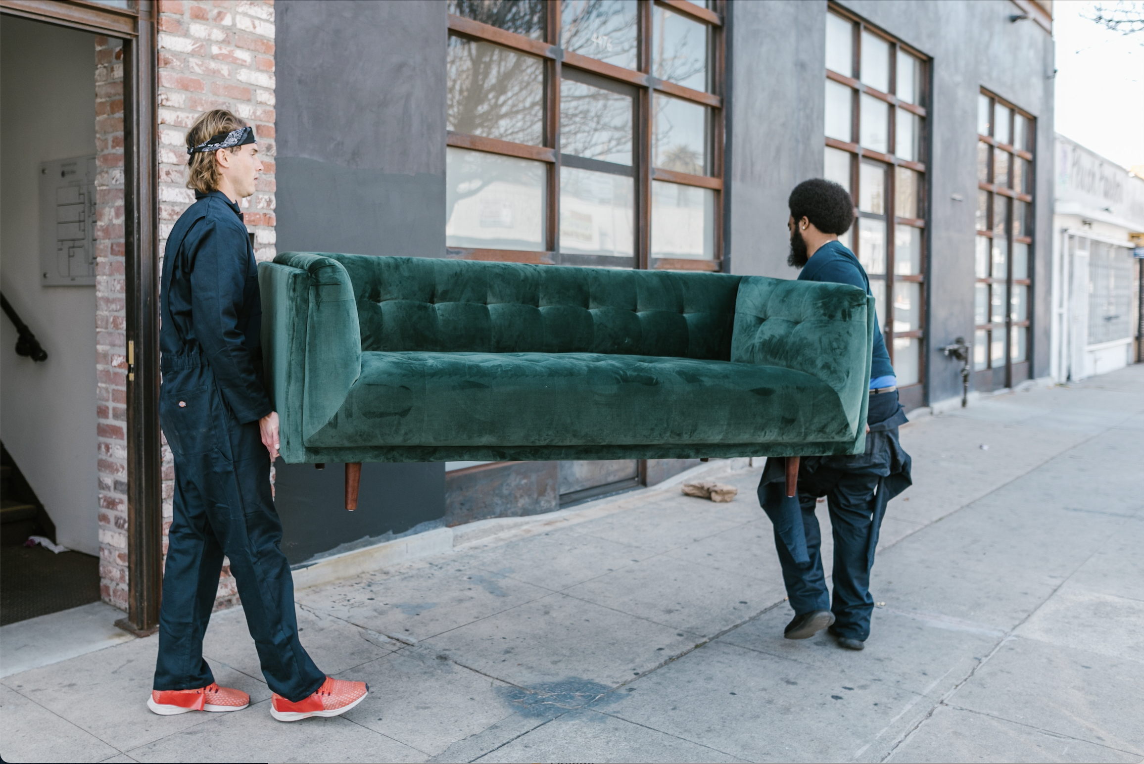 zwei umzugshelfer tragen ein sofa