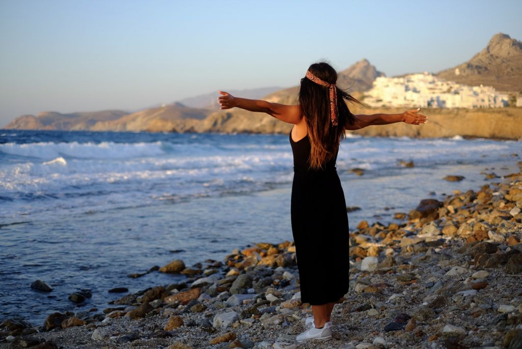 Eine glückliche Frau die den Strand genießt nach ihrem erfolgreichen Umzug nach Griechenland